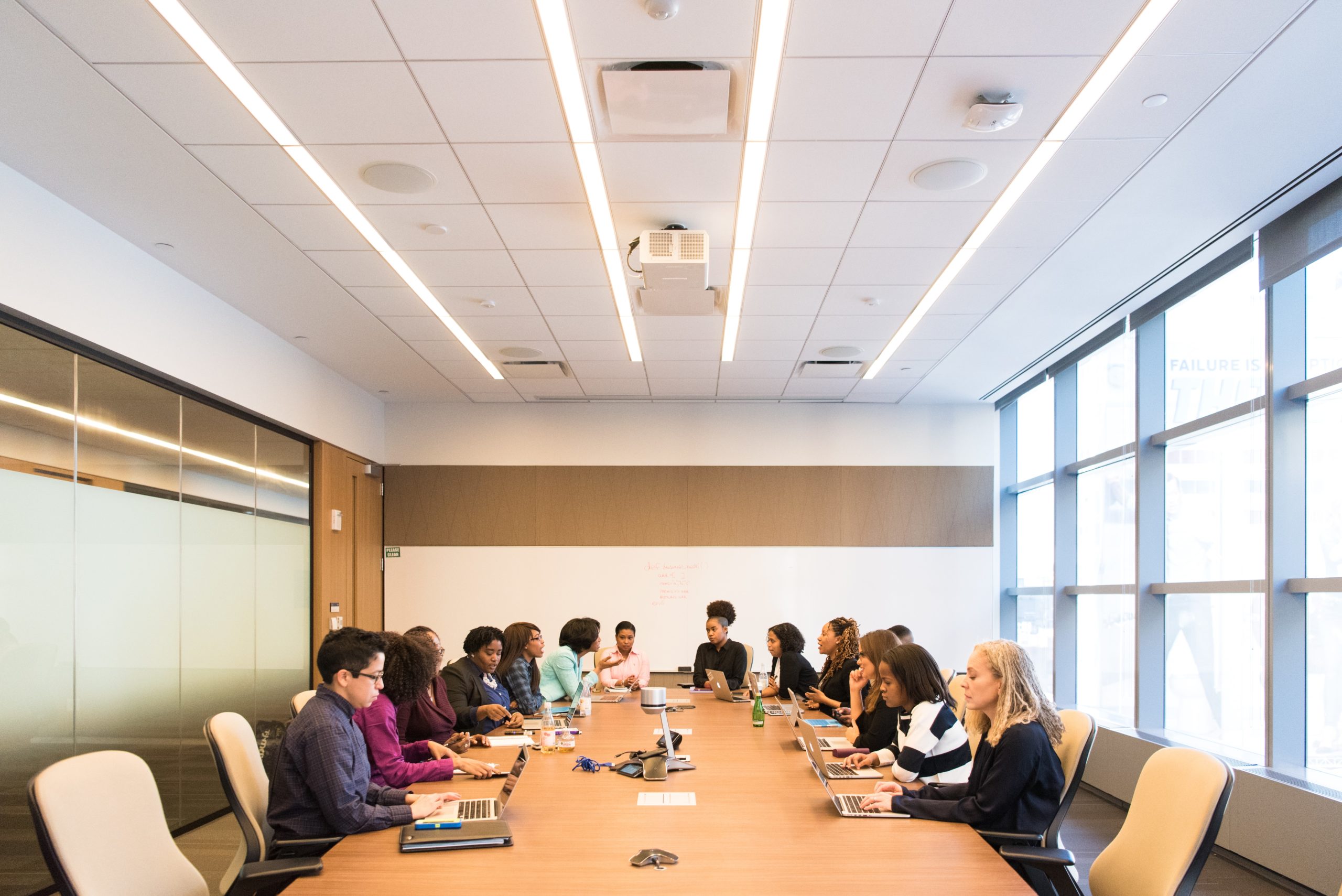 diverse group of colleagues sit around an office meeting table